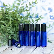 Cobalt blue roller bottles in front of greenery.